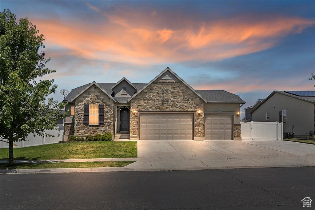 Craftsman-style house with stone siding, an attached garage, and concrete driveway