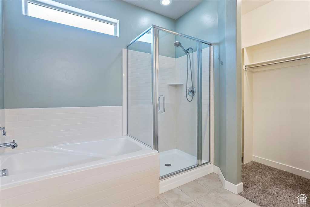 Full bathroom with a shower stall, a bath, and tile patterned floors