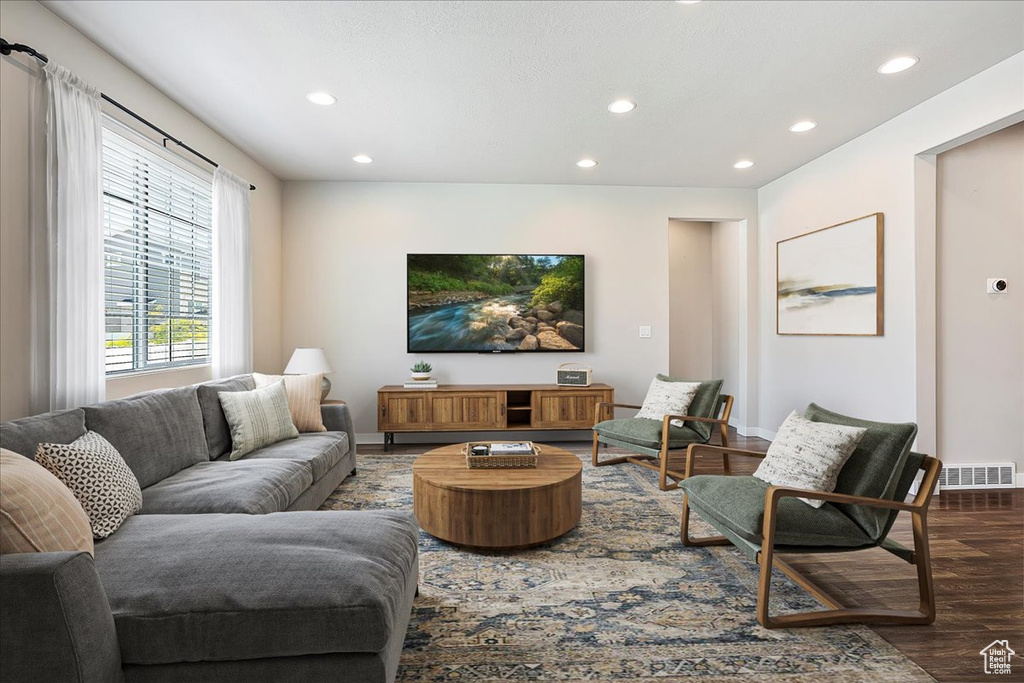 Living area featuring dark wood-style flooring and recessed lighting