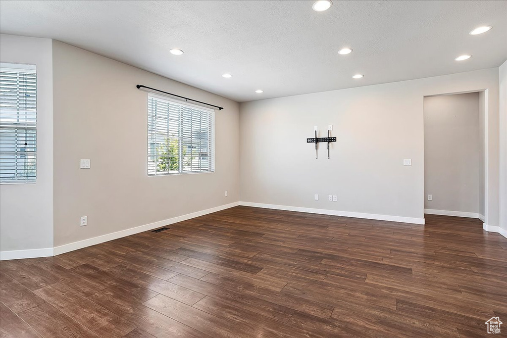 Unfurnished room with dark wood-style flooring, recessed lighting, and a textured ceiling