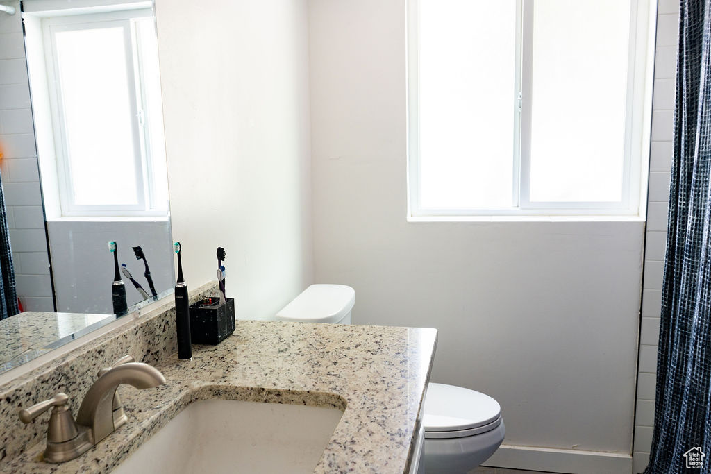 Full bath with healthy amount of natural light, vanity, and a shower with shower curtain
