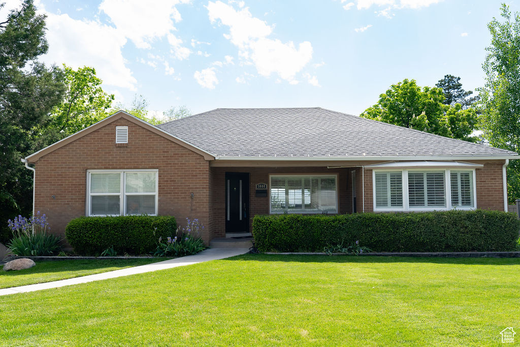 Single story home with brick siding, a front lawn, and a shingled roof