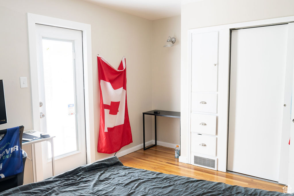 Bedroom with wood finished floors and a closet