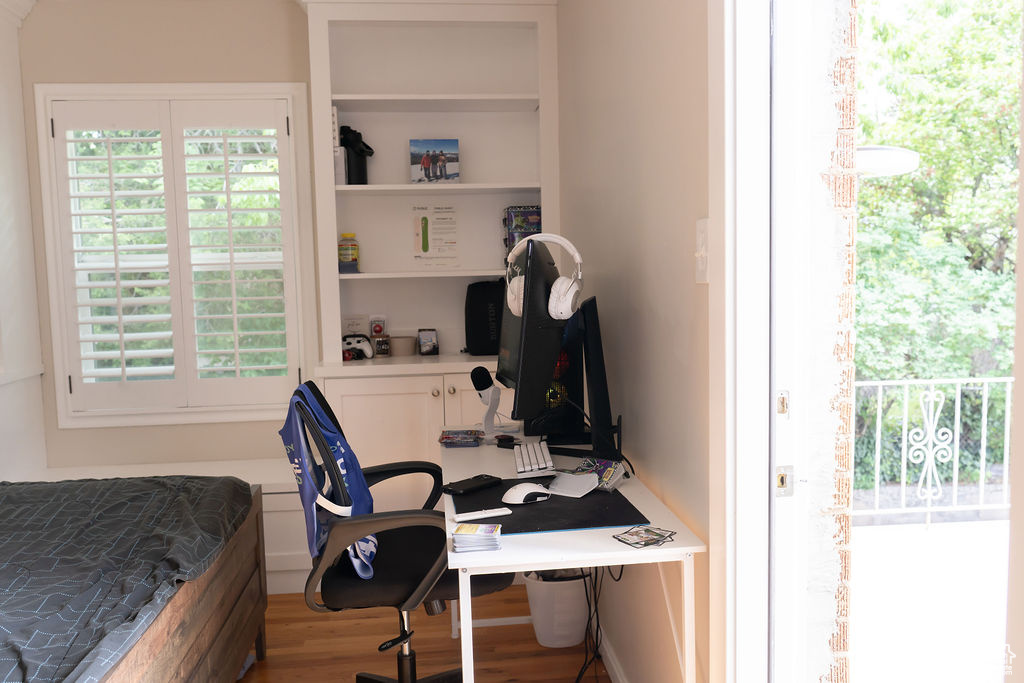 Bedroom featuring wood finished floors and an office area