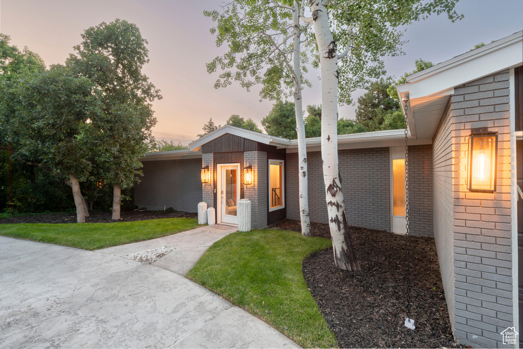 View of front of home with brick siding and a front lawn