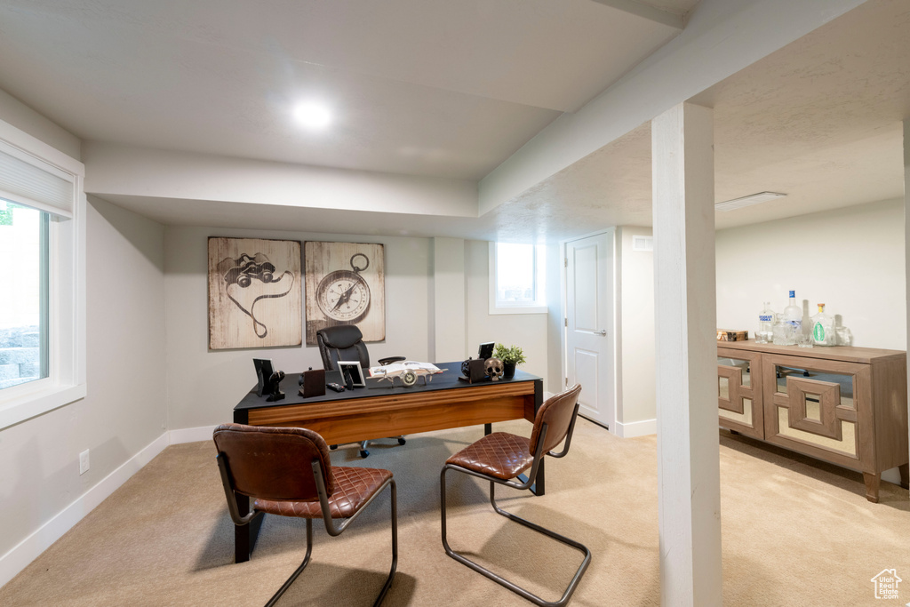 Office space with light carpet and baseboards