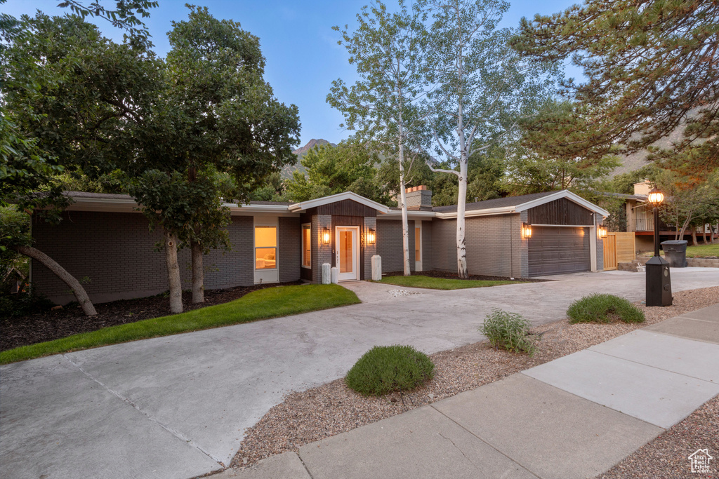 Mid-century inspired home with brick siding and concrete driveway