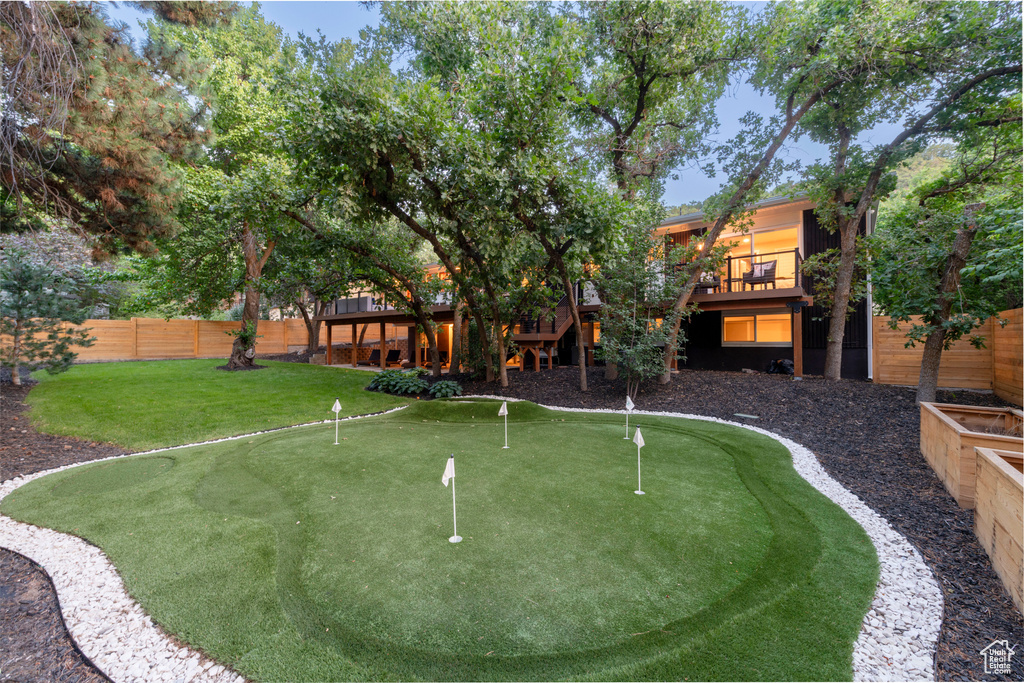 View of yard featuring a putting area and a wooden deck