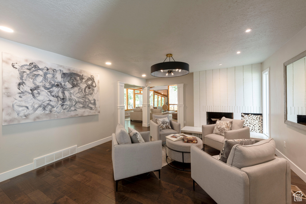 Living area featuring dark wood-type flooring, recessed lighting, and a textured ceiling