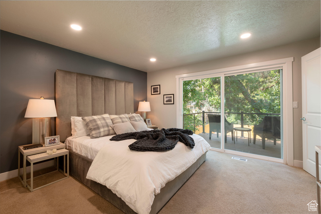 Carpeted bedroom with access to exterior, recessed lighting, and a textured ceiling