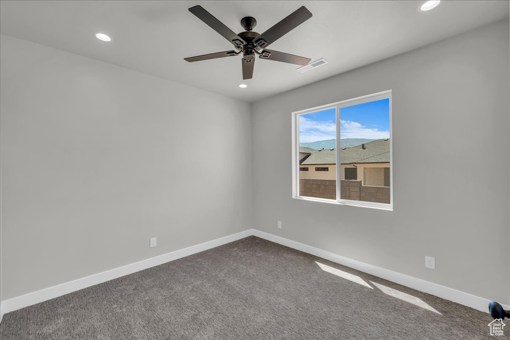 Spare room with recessed lighting, dark carpet, and ceiling fan