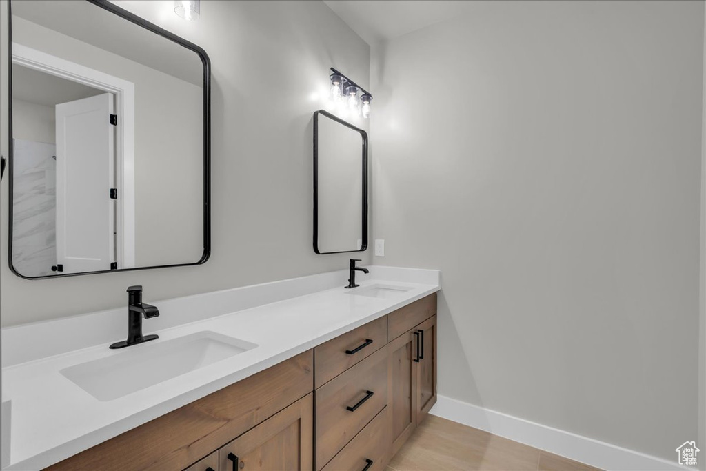 Bathroom with double vanity and baseboards