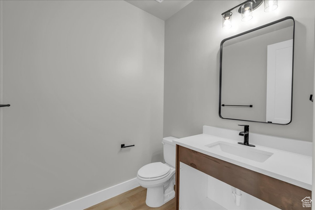Half bathroom featuring wood finished floors and vanity