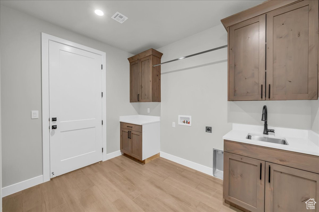 Laundry room featuring hookup for a washing machine, hookup for an electric dryer, light wood-style floors, recessed lighting, and cabinet space