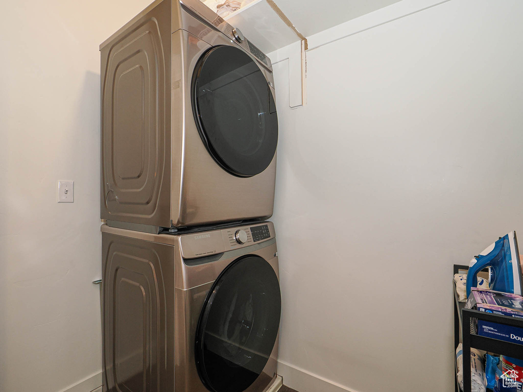 Laundry area with stacked washer / dryer and baseboards