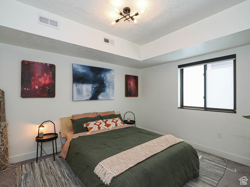 Bedroom with a textured ceiling and baseboards