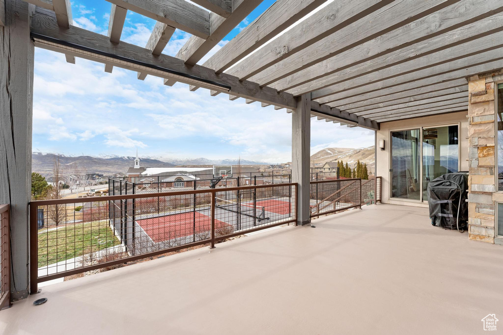 View of patio with a mountain view, grilling area, and a pergola