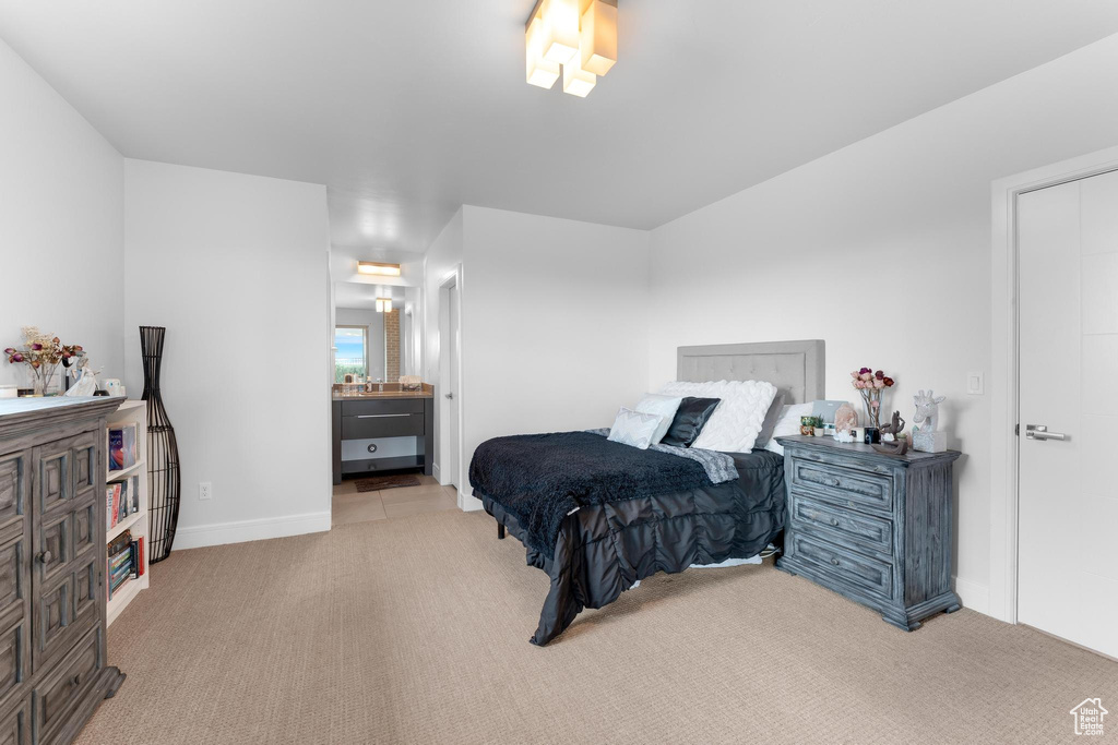 Bedroom featuring light carpet and ensuite bath