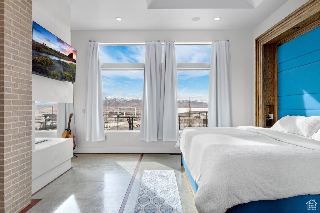 Bedroom featuring finished concrete floors, recessed lighting, and multiple windows