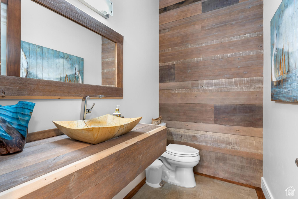 Bathroom featuring toilet and wooden walls
