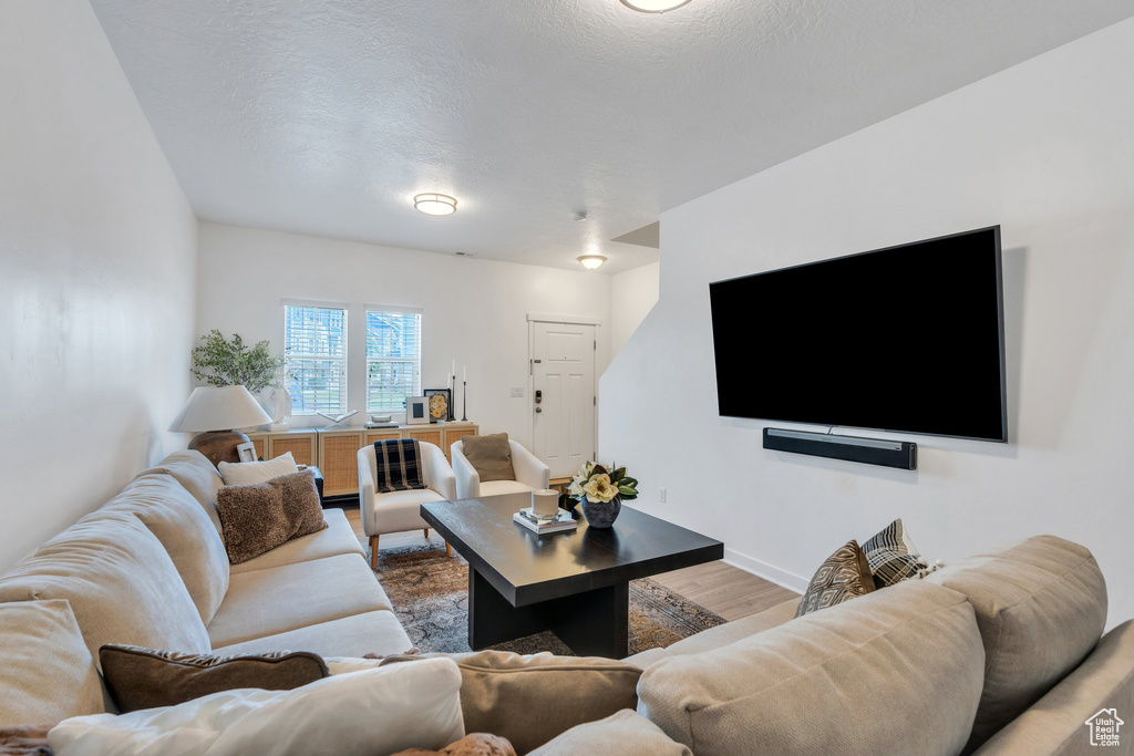 Living room with wood finished floors and a textured ceiling