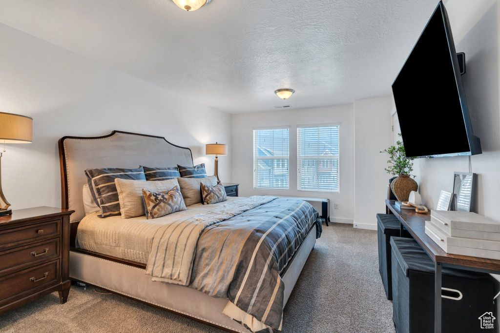 Bedroom with light carpet and a textured ceiling