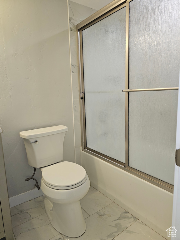 Full bath featuring marble finish floors and enclosed tub / shower combo