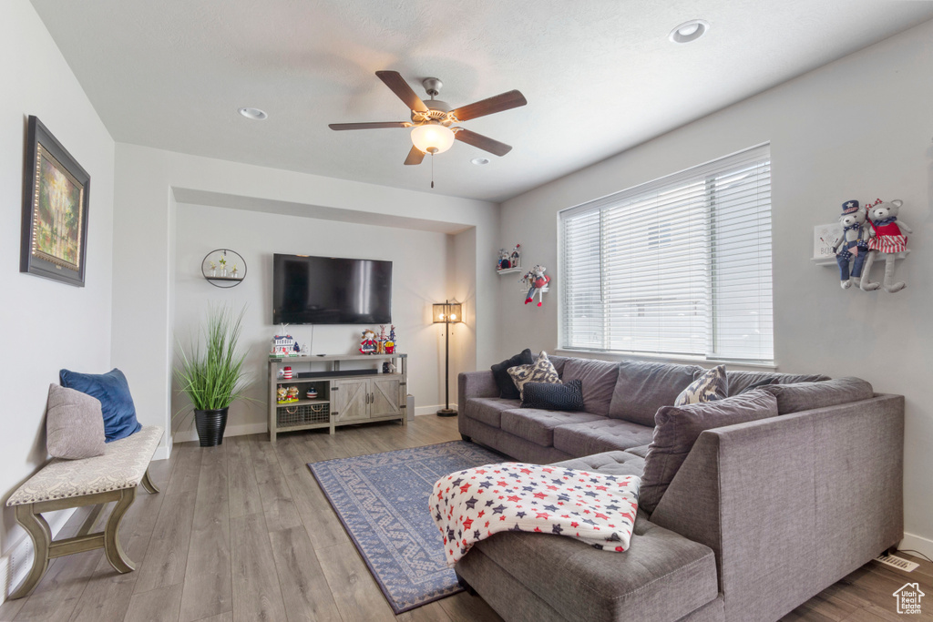 Living room featuring a ceiling fan, wood finished floors, and recessed lighting