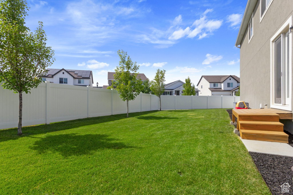 Fenced backyard featuring a residential view and a wooden deck