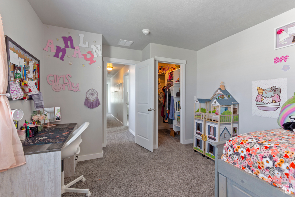 Bedroom with carpet, a spacious closet, and a closet