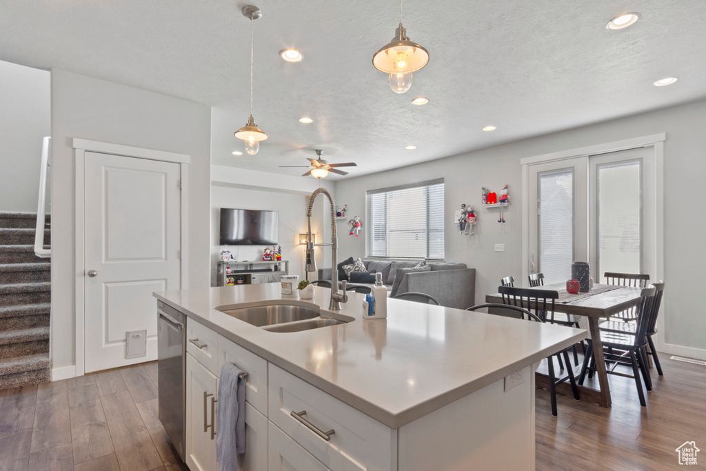 Kitchen featuring stainless steel dishwasher, pendant lighting, white cabinetry, recessed lighting, and a textured ceiling