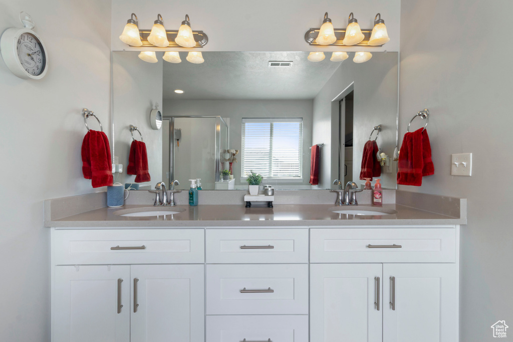 Full bathroom with double vanity and a shower stall