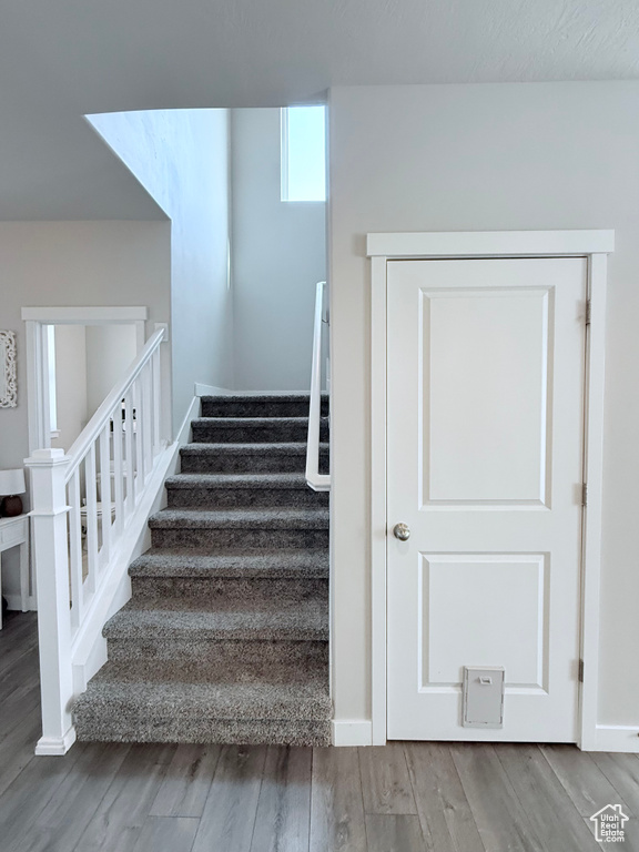 Stairway with wood finished floors and baseboards