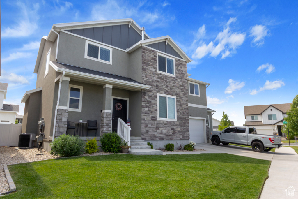 View of front facade featuring stone siding, board and batten siding, a garage, stucco siding, and driveway