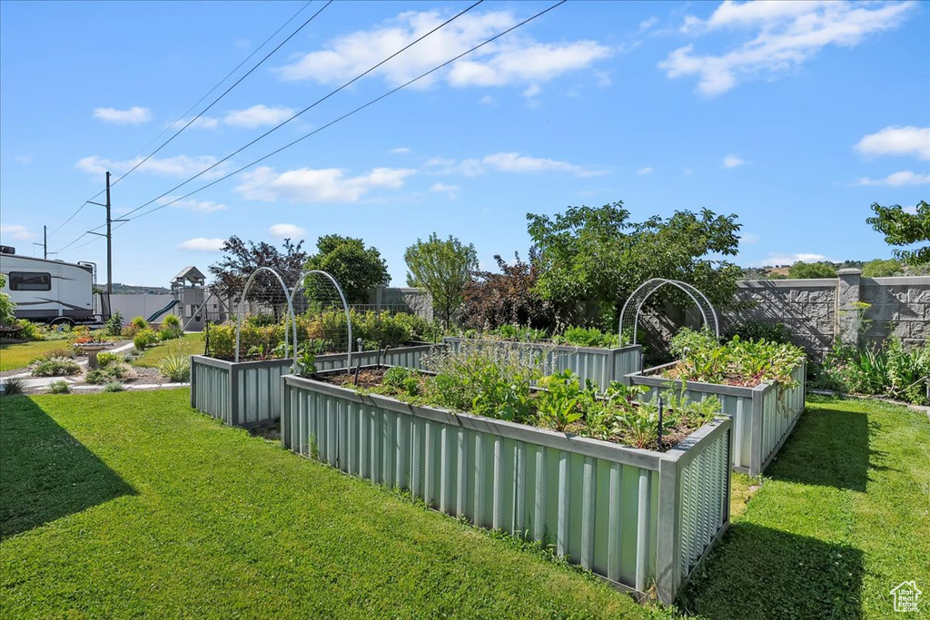 View of grassy yard featuring a garden