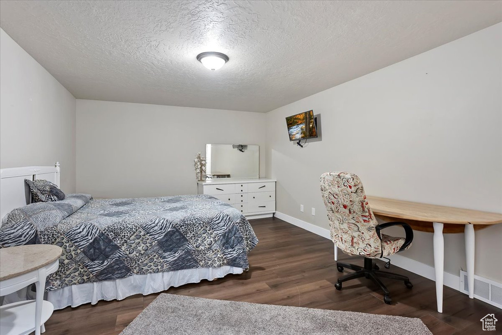 Bedroom featuring wood finished floors and a textured ceiling