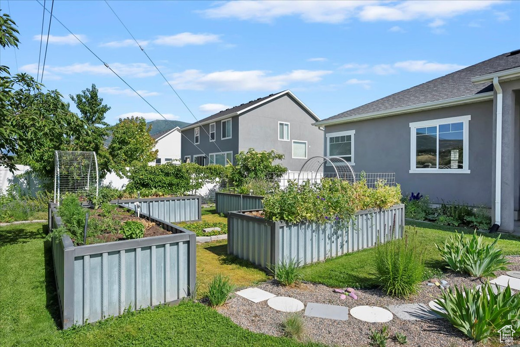 View of grassy yard featuring a vegetable garden