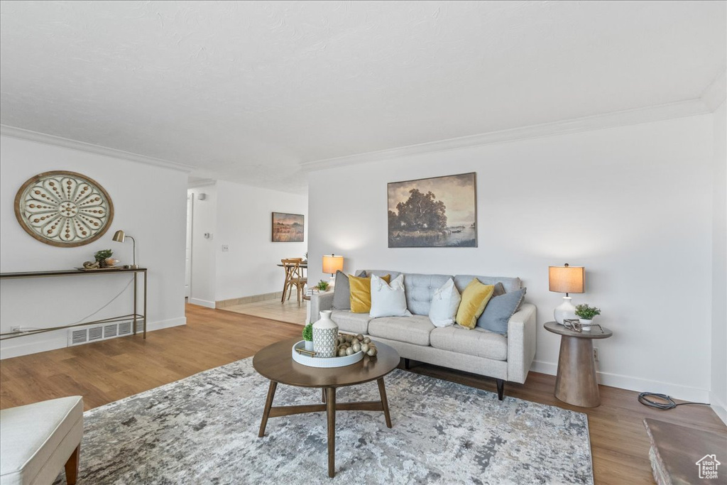 Living room featuring ornamental molding and wood finished floors