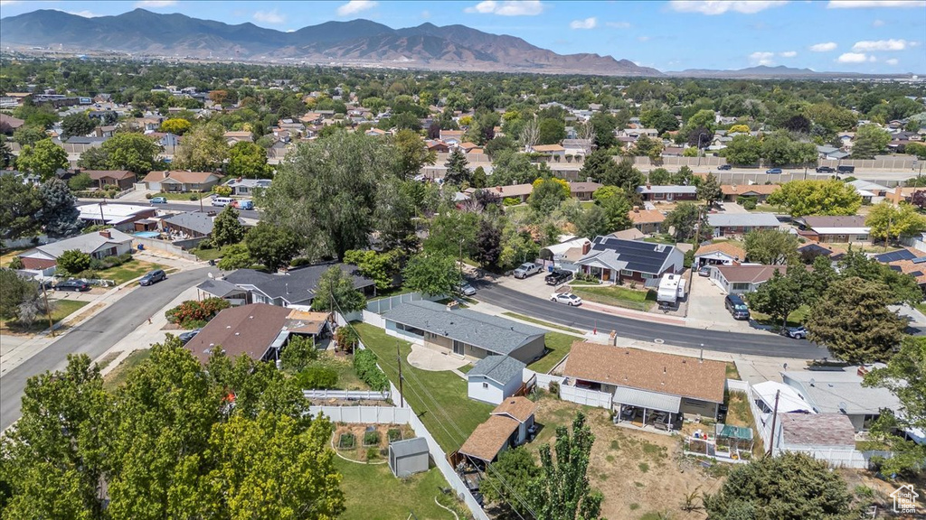 Aerial view of property and surrounding area with a mountainous background and nearby suburban area
