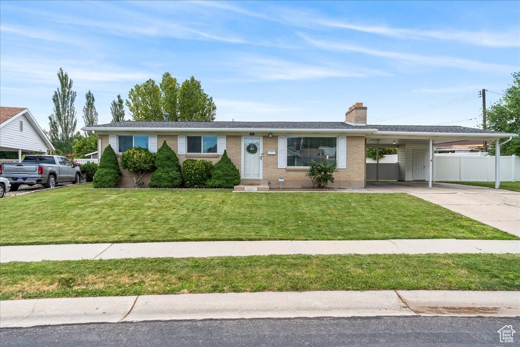 Ranch-style home featuring concrete driveway, an attached carport, a chimney, entry steps, and brick siding