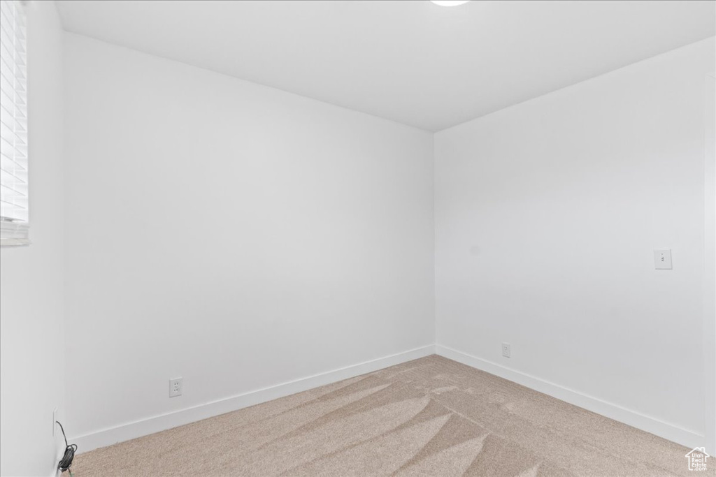 Carpeted spare room with baseboards