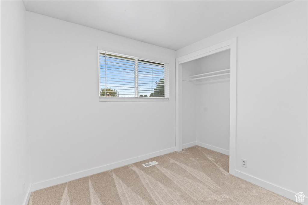 Unfurnished bedroom featuring carpet floors and a closet
