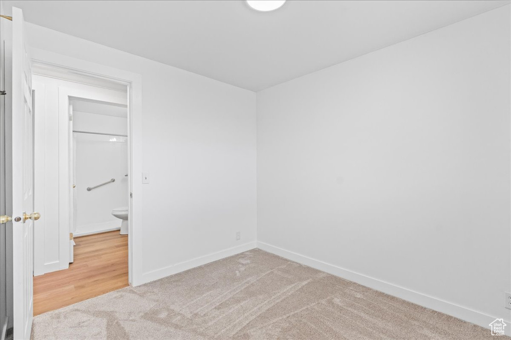 Carpeted empty room with baseboards