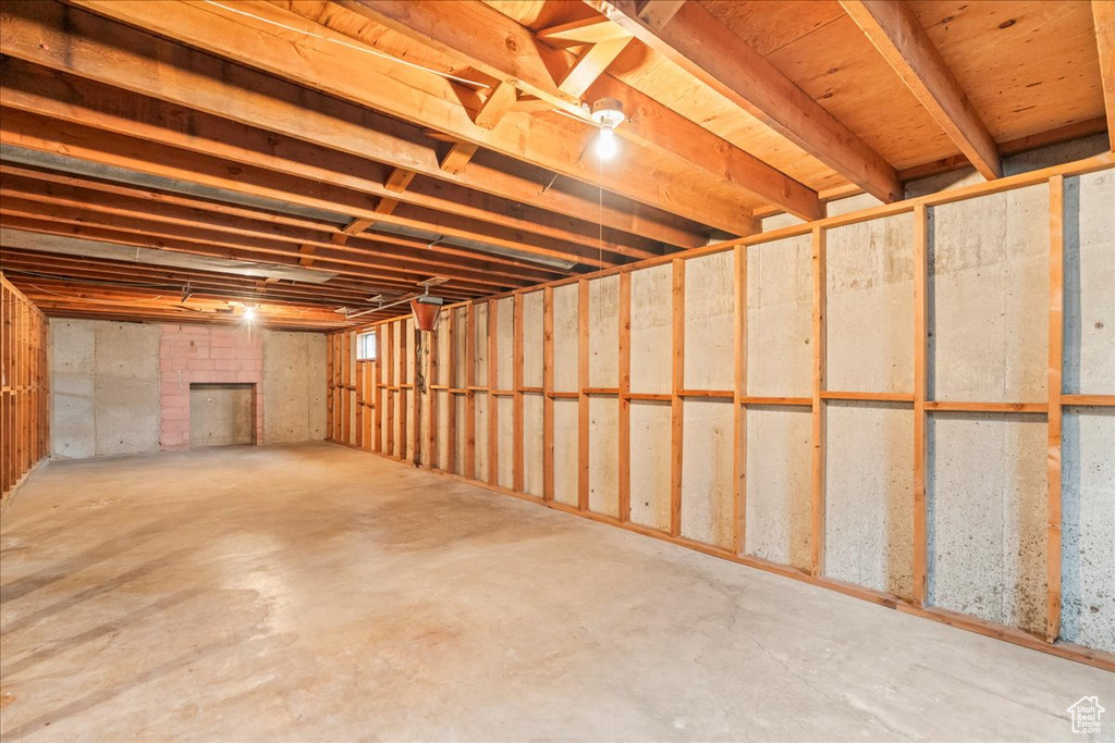Unfinished below grade area featuring a brick fireplace