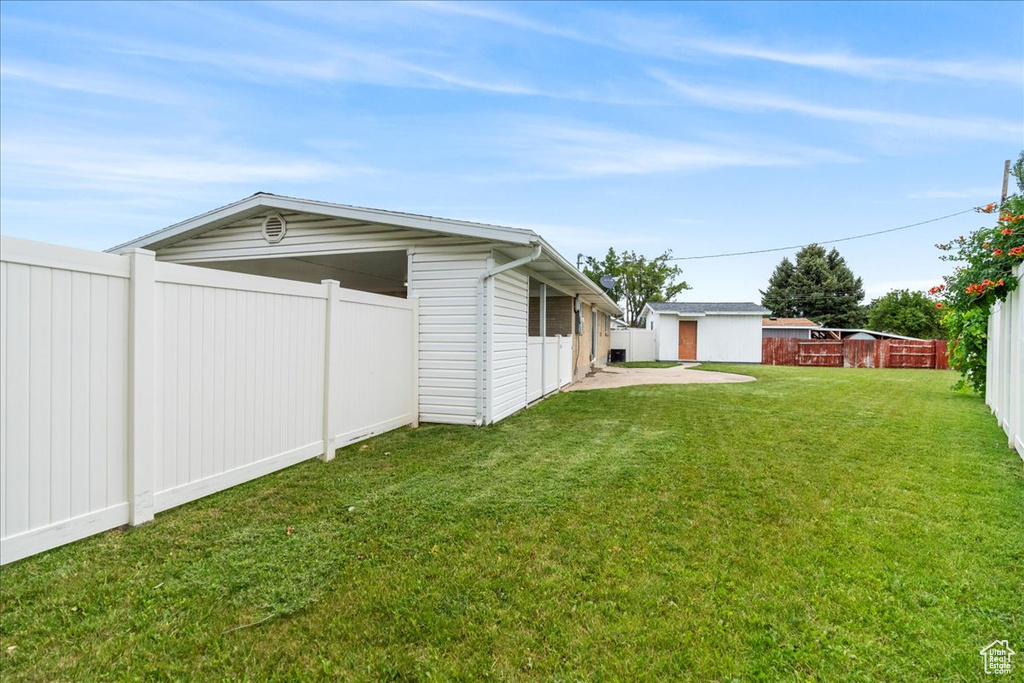 Fenced backyard featuring an outdoor structure
