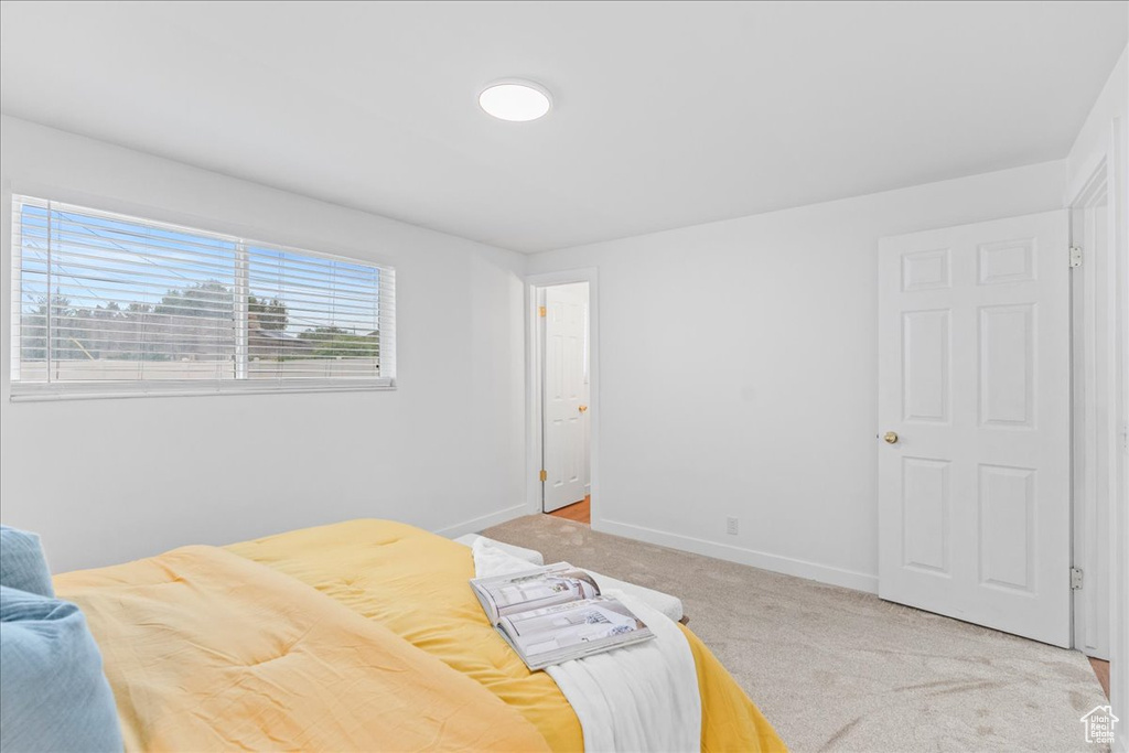 Bedroom with light carpet and baseboards