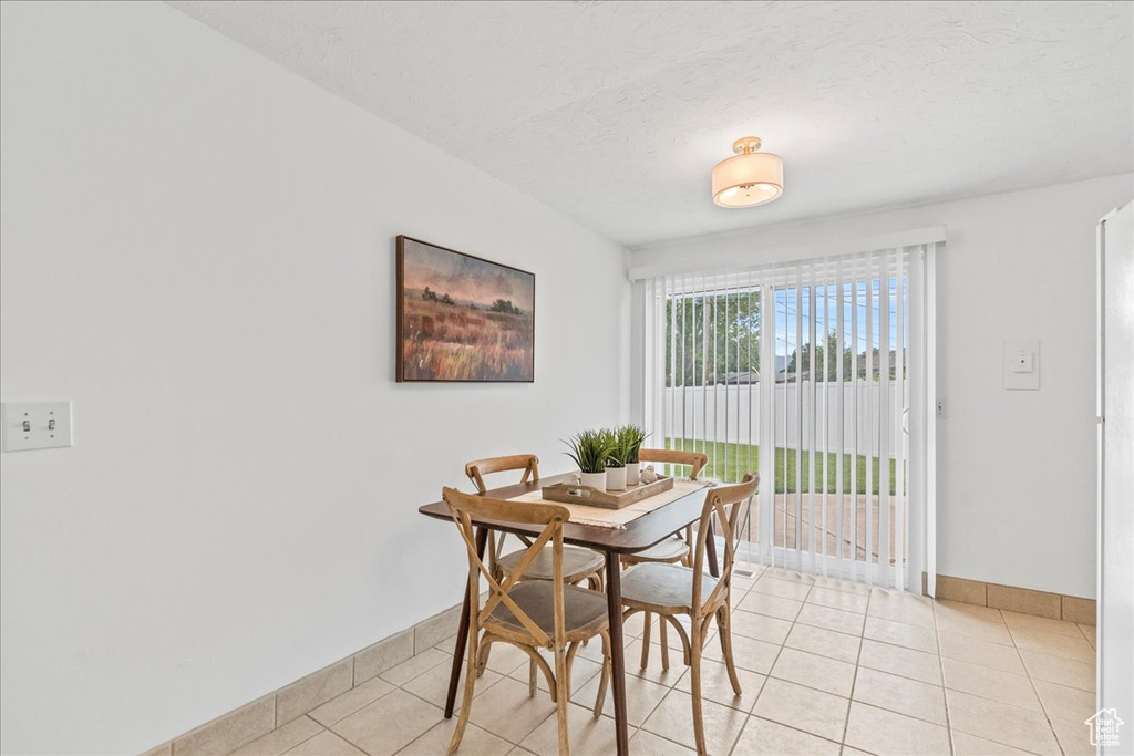 Dining room featuring light tile patterned floors and baseboards