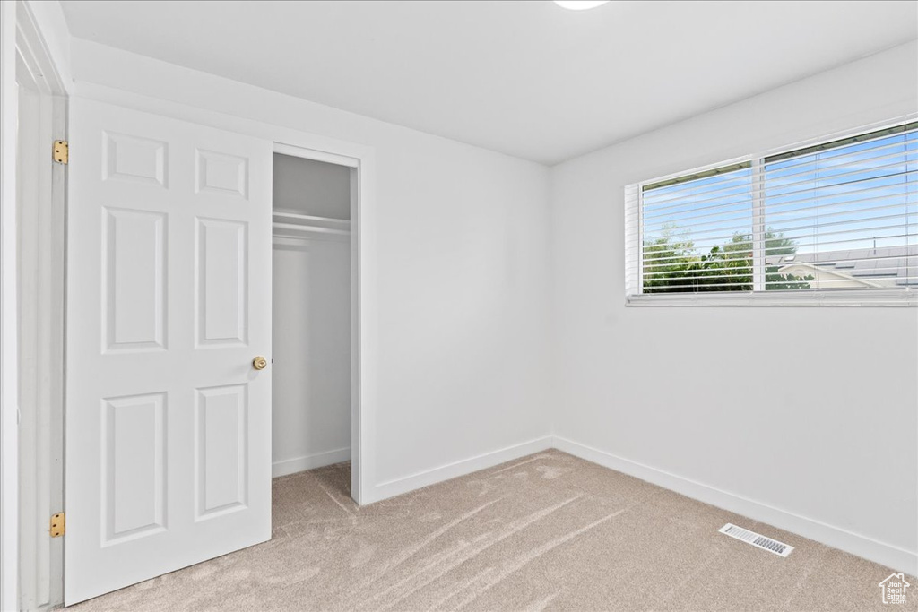 Unfurnished bedroom featuring carpet floors and a closet