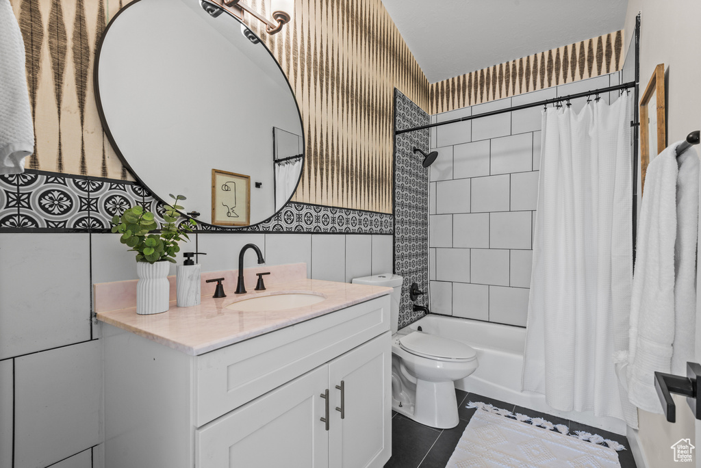 Full bath featuring vanity, tile patterned flooring, shower / tub combo, and tile walls