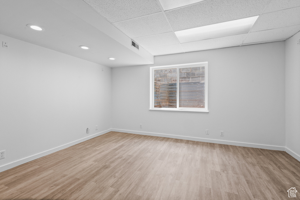 Unfurnished room featuring light wood-style floors, a drop ceiling, and recessed lighting